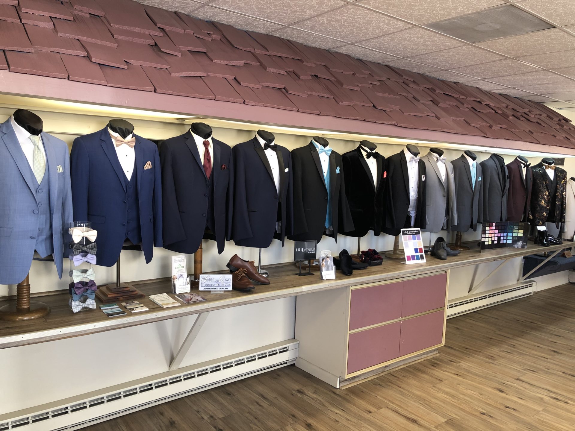 A row of suits hanging on the wall.
